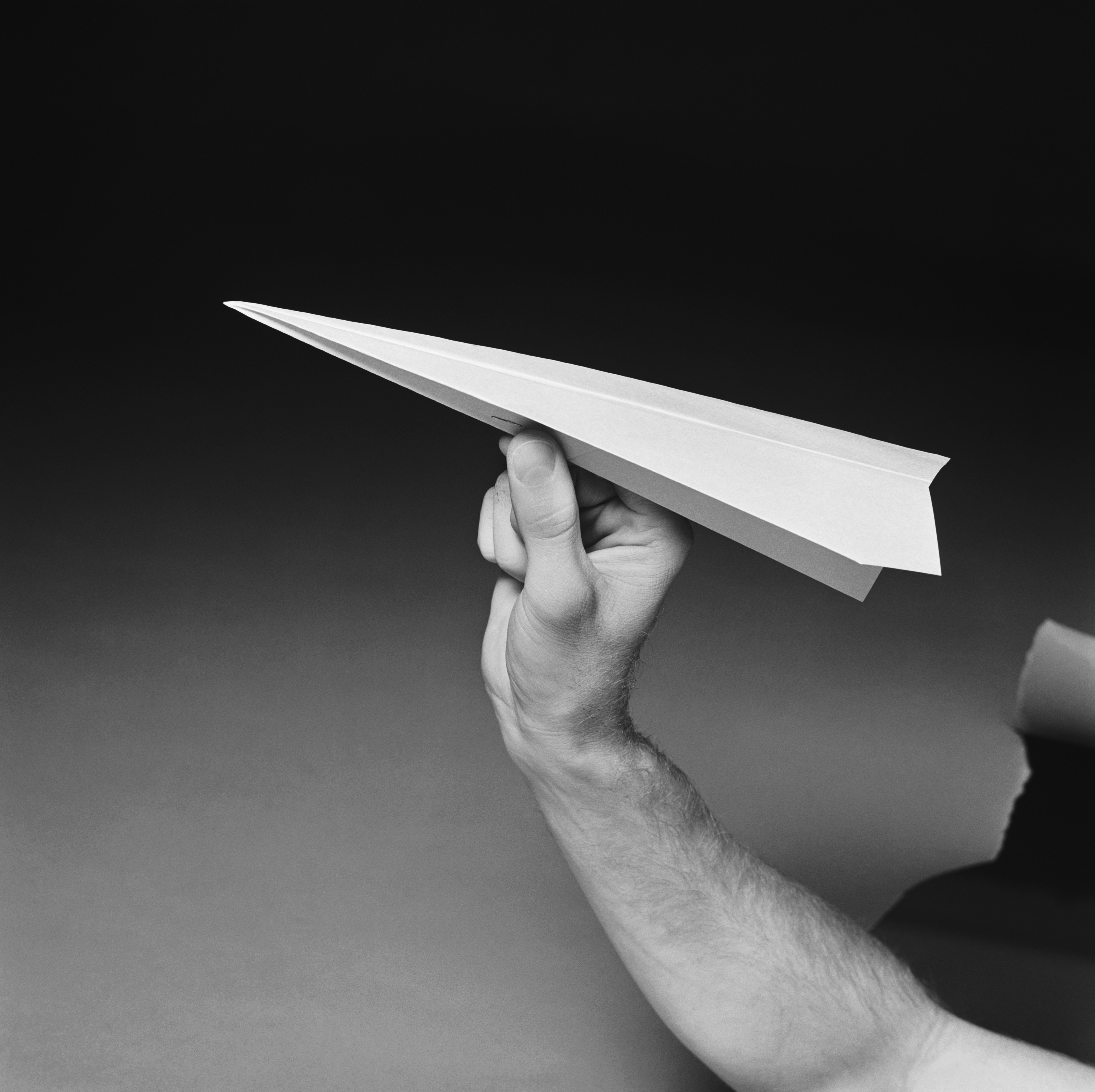 A hand holding a paper airplane