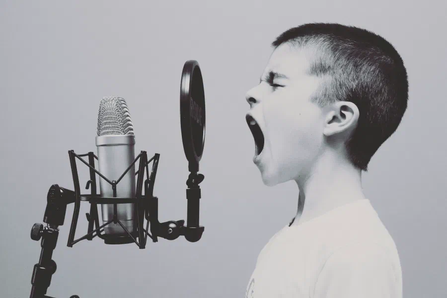 A child speaking into a studio microphone